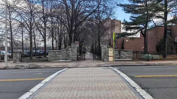 Tree-lined campus walkway and stone gates
