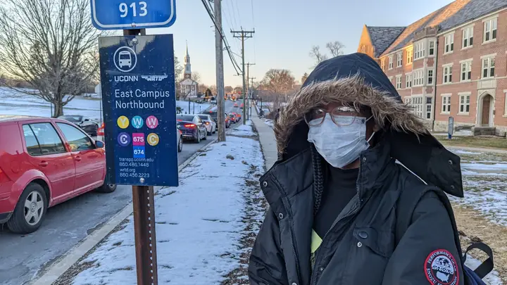 Portrait beside a UConn bus stop in winter